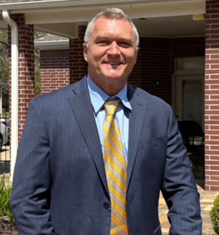 Dr. Michael G. Moore, DDS, in a blue suit and gold tie.