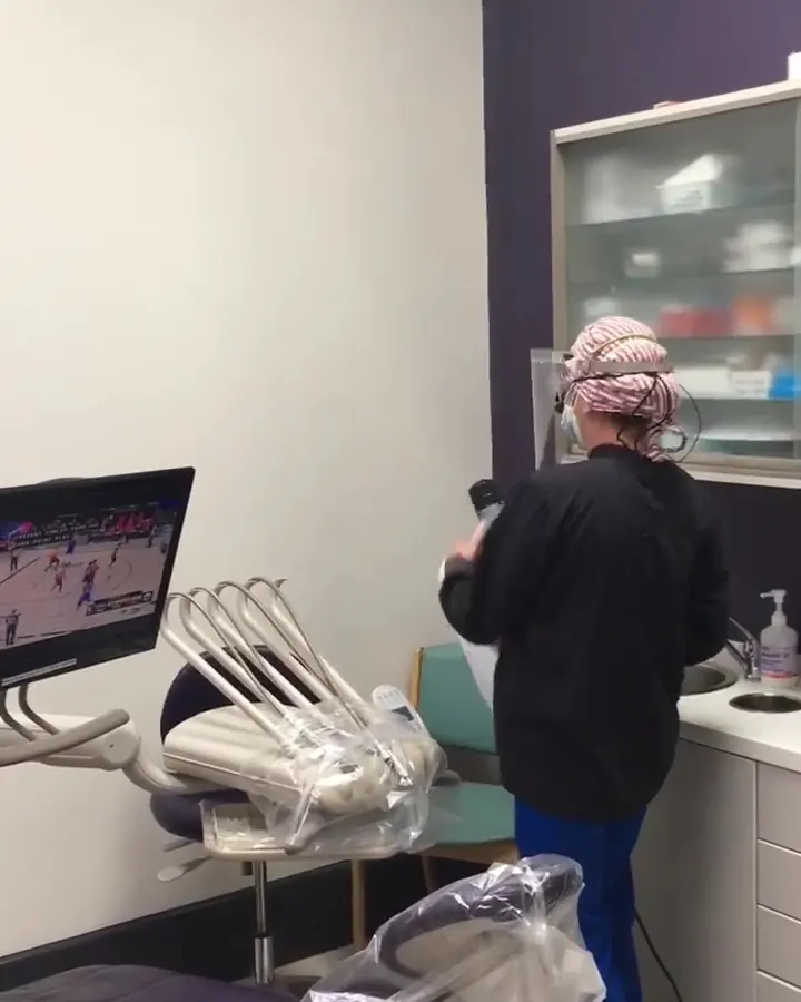 A hygienist preparing a treatment room.